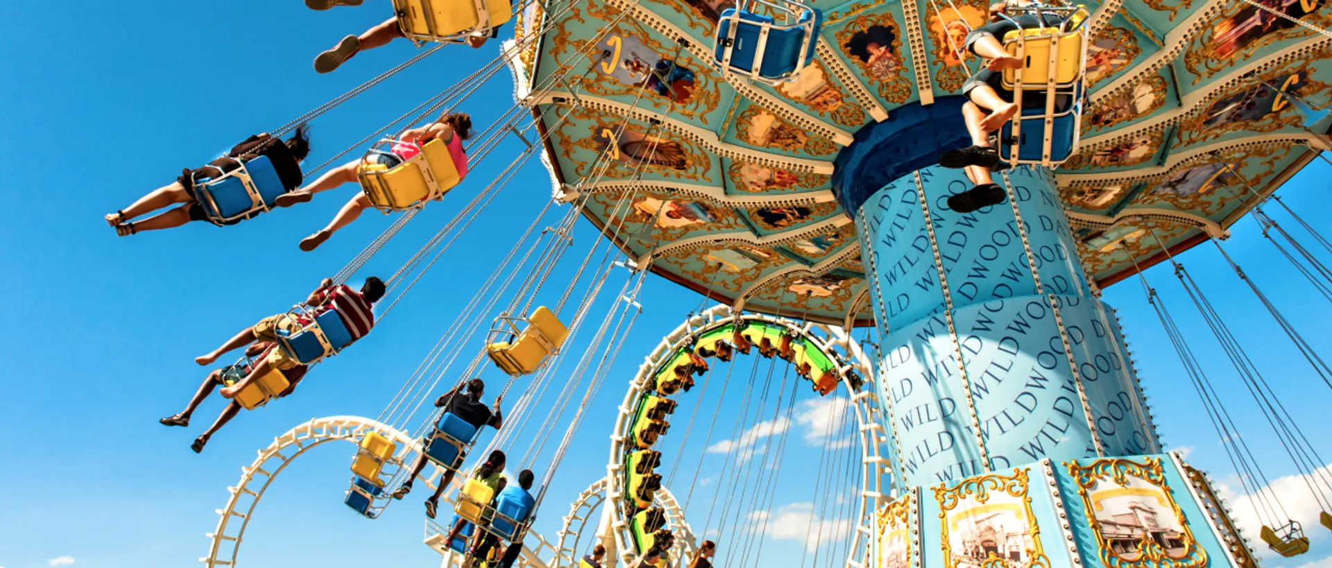 Riders soaring on the swing ride beside a roller coaster at Morey’s Piers